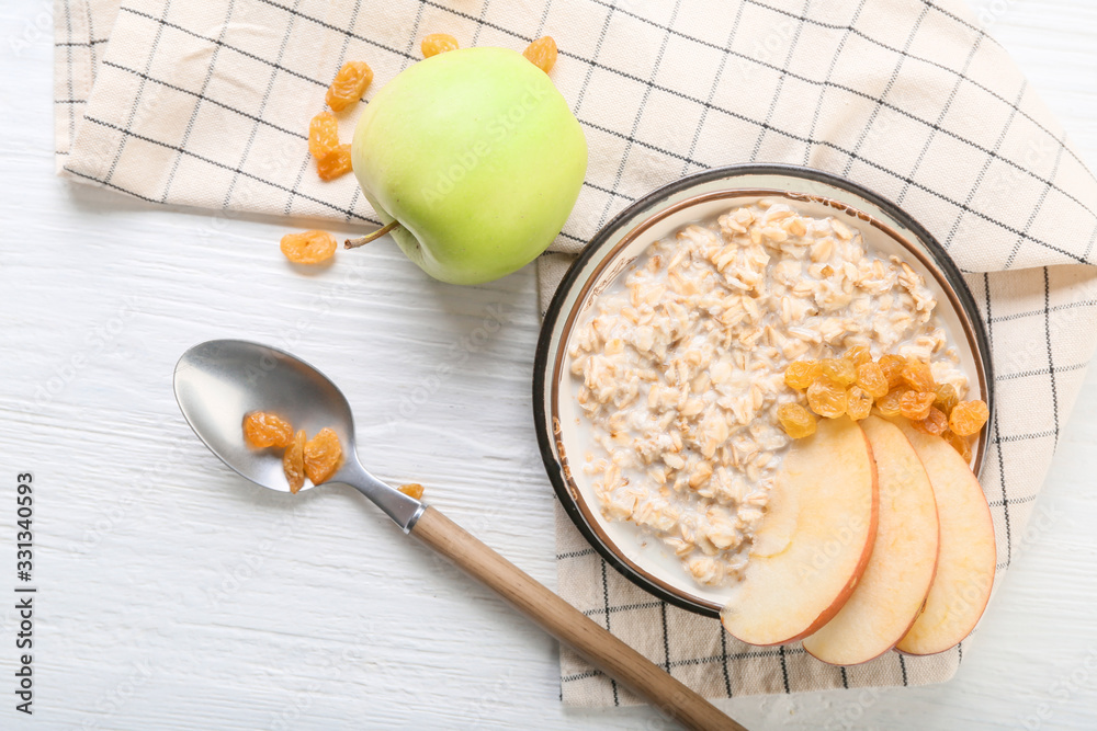 Bowl with tasty sweet oatmeal on table