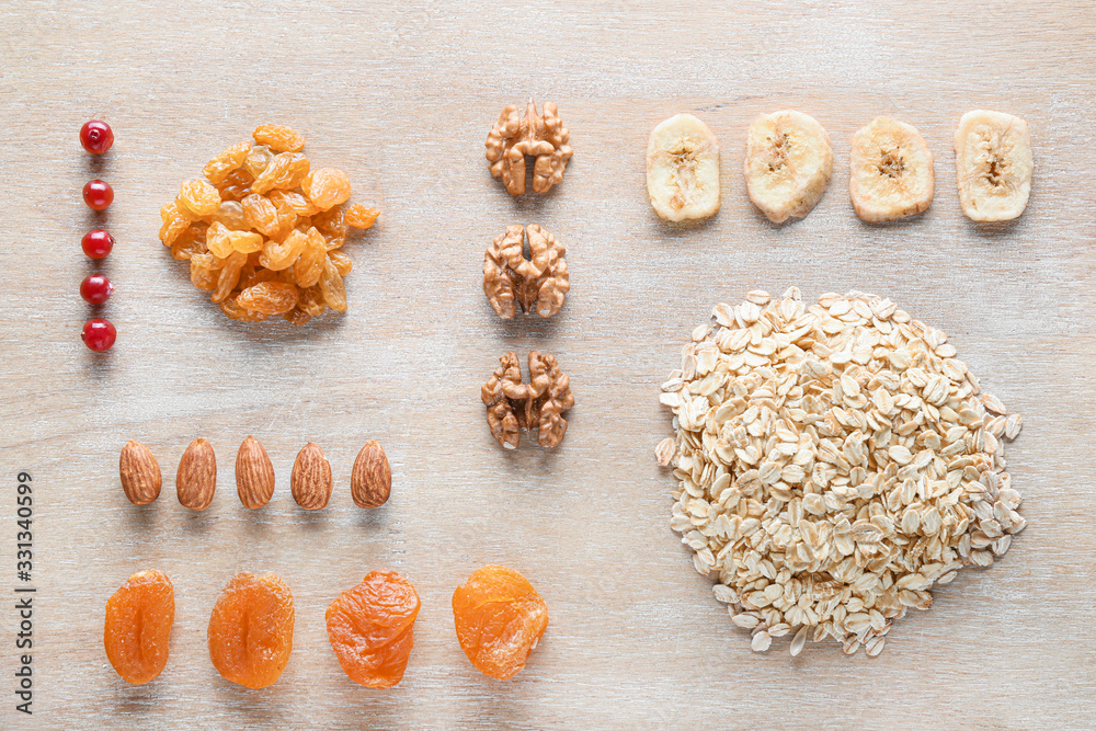 Dry oat grains with fruits and nuts on wooden background