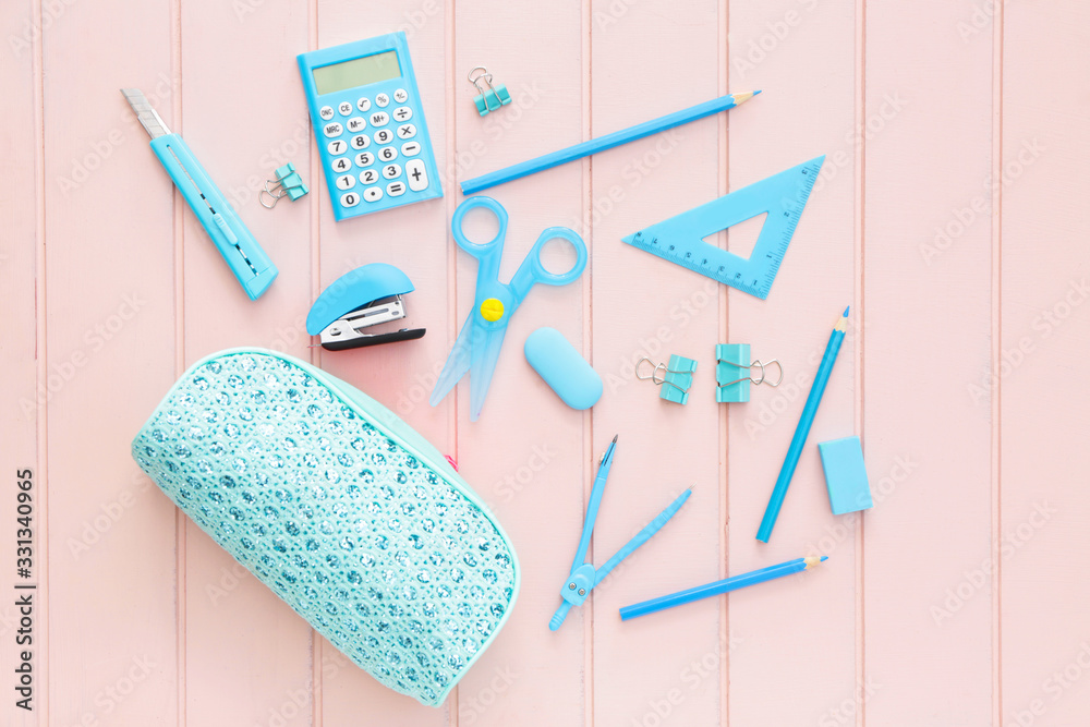 Pencil case and school stationery on wooden background