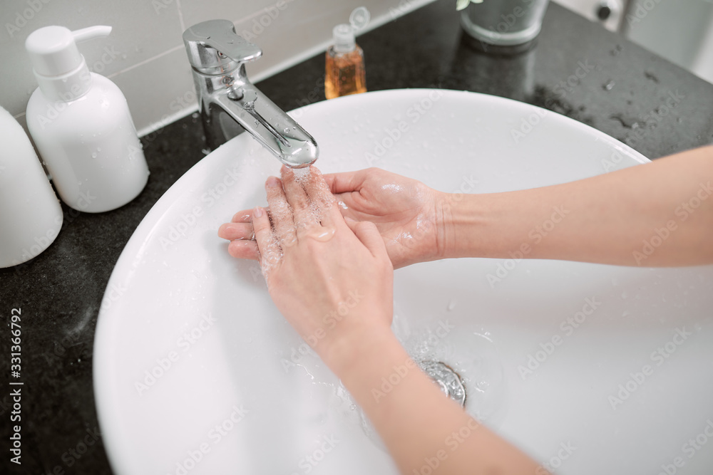 Washing hands with soap in bathroom, closeup