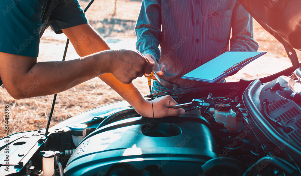 The owner of the garage and the mechanic check the customers car,Car maintenance concept,Check the 