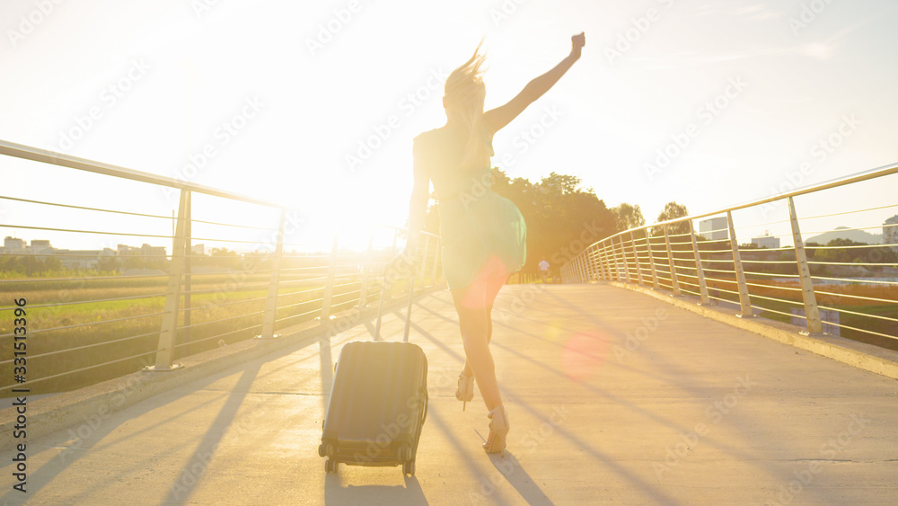 LENS FLARE: Fashionable blonde tourist girl is excited to go on another trip