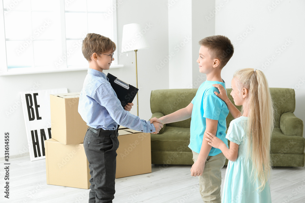 Little real estate agent with clients shaking hands indoors