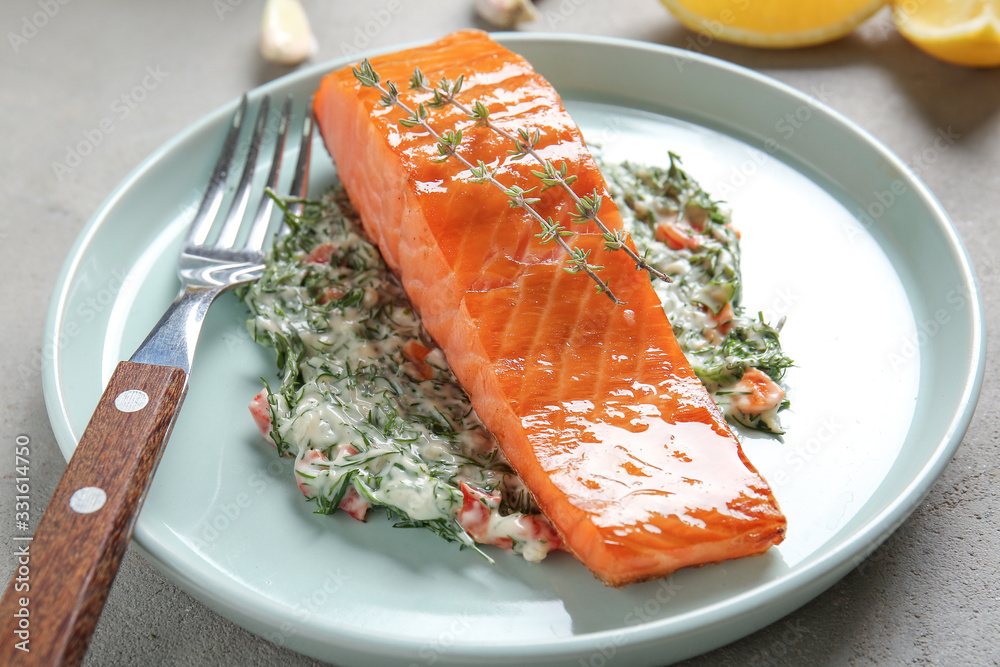 Cooked salmon fillet and sauce on plate