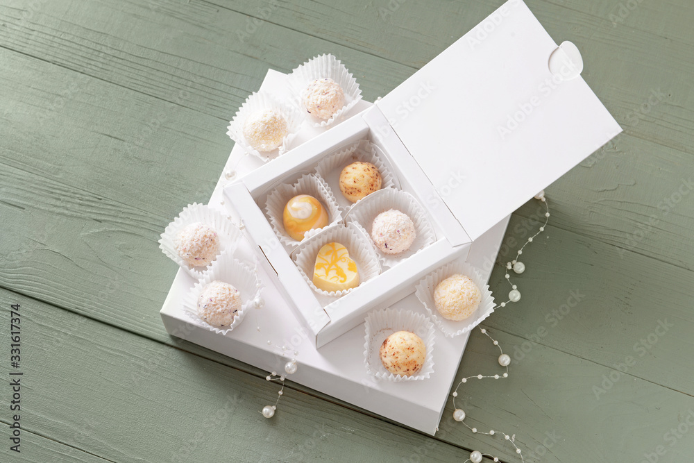 Box with delicious candies on wooden background