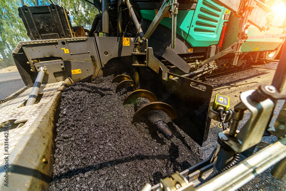 Industrial pavement truck. Laying fresh asphalt on construction site. Heavy machine industry. Mechan