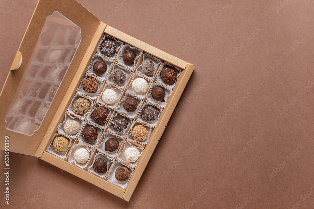 Box with delicious candies on color background