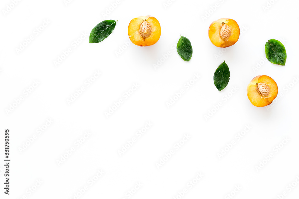 Peach slices and leaves pattern on white background top-down frame copy space