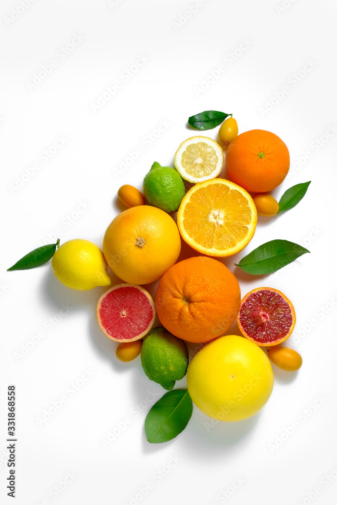 Close up image of juicy organic whole and halved assorted citrus fruits, green leaves & visible core