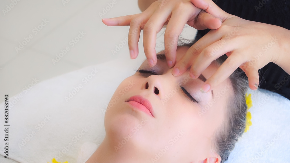 Woman gets facial and head massage in luxury spa.