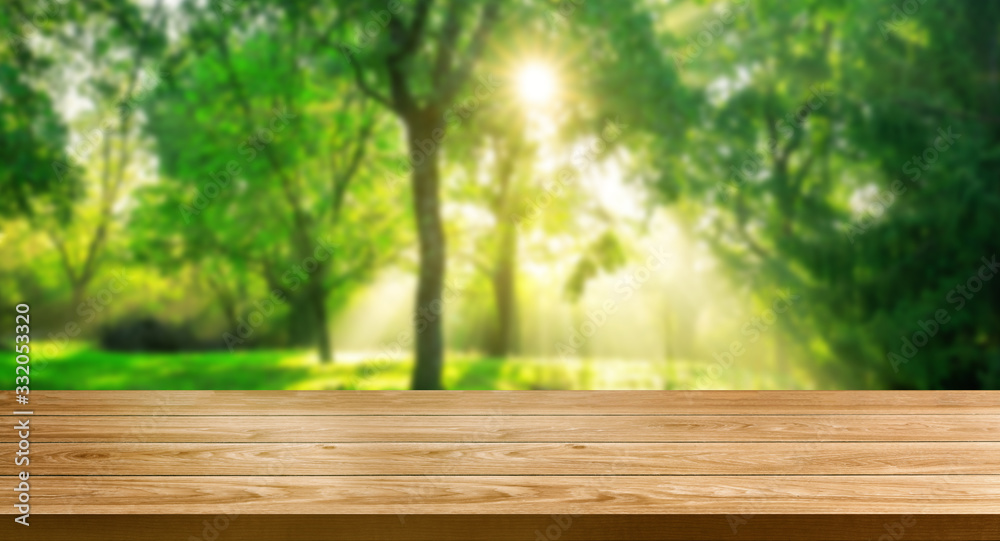 Brown wood table in green blur nature background.