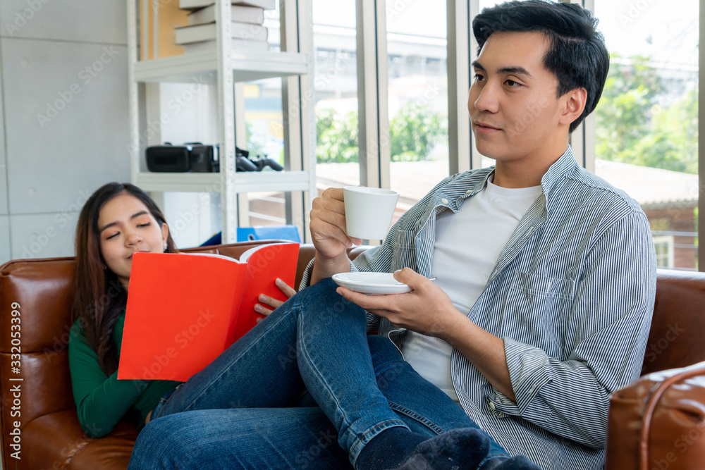 Happy Asian couple drink coffee at home.