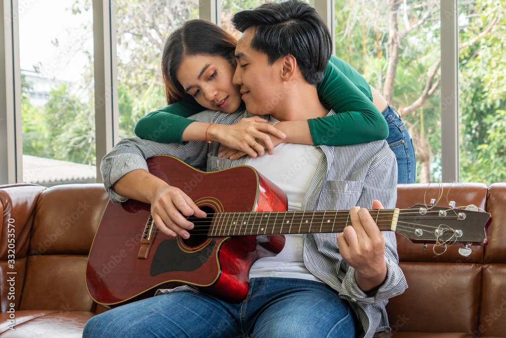 Young Asian Couple Plays Guitar and Sing Song