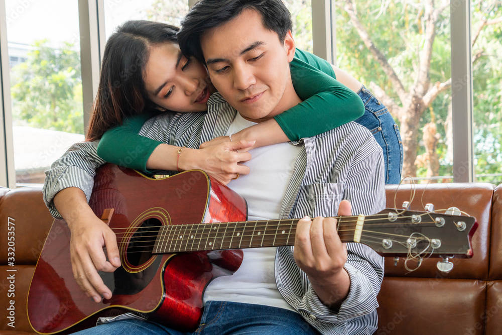 Young Asian Couple Plays Guitar and Sing Song