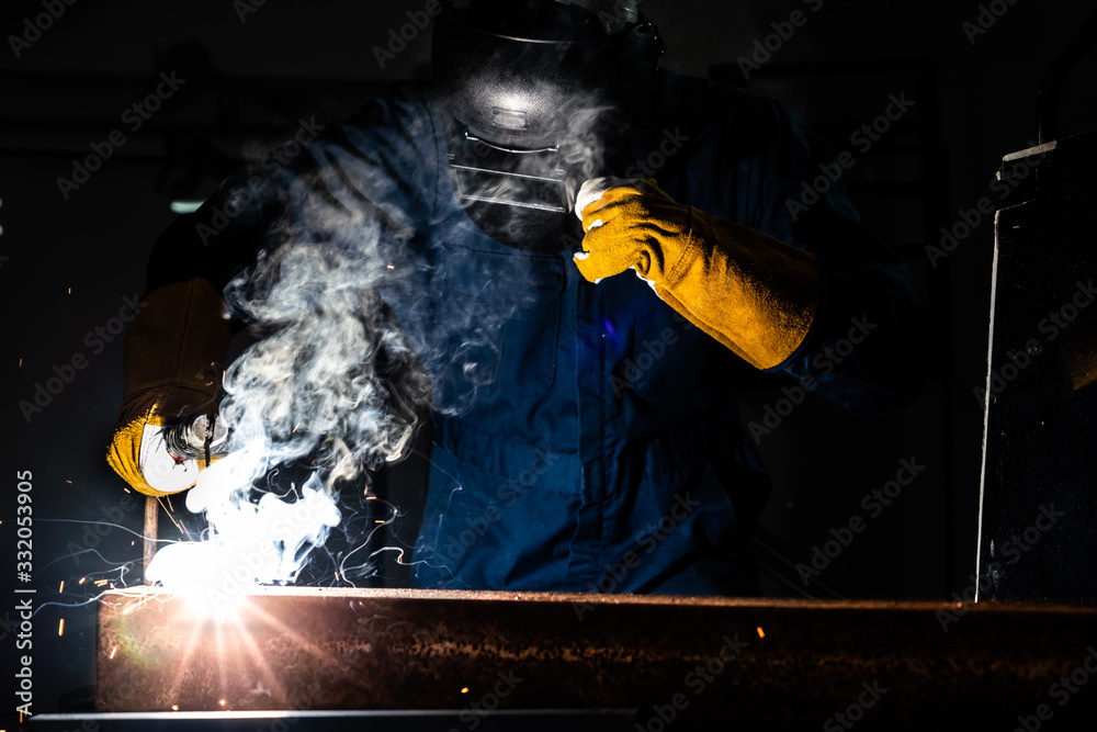 Metal welder working with arc welding machine.