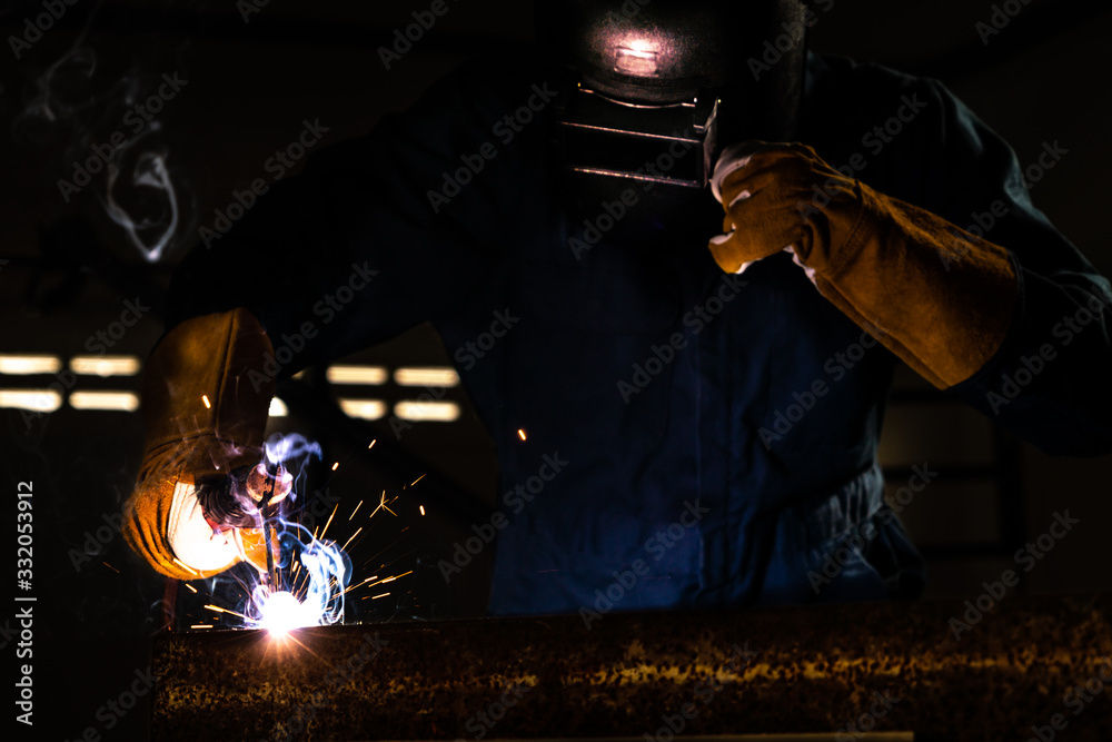 Metal welder working with arc welding machine.