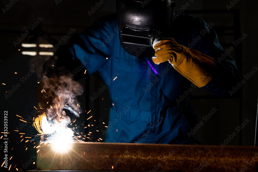 Metal welder working with arc welding machine.