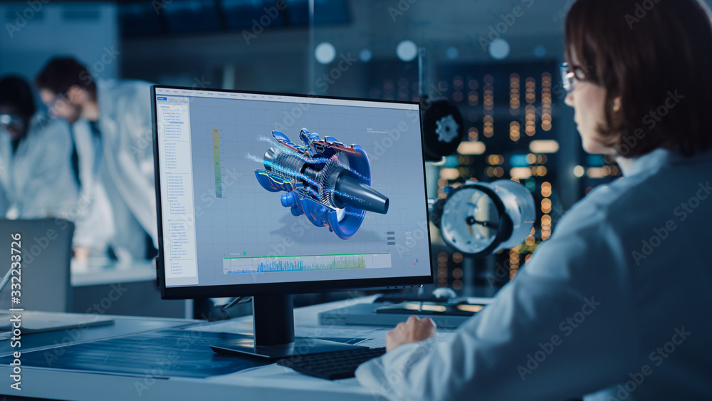 肩上射击：女性IT科学家使用计算机显示飞机发动机的CAD软件。