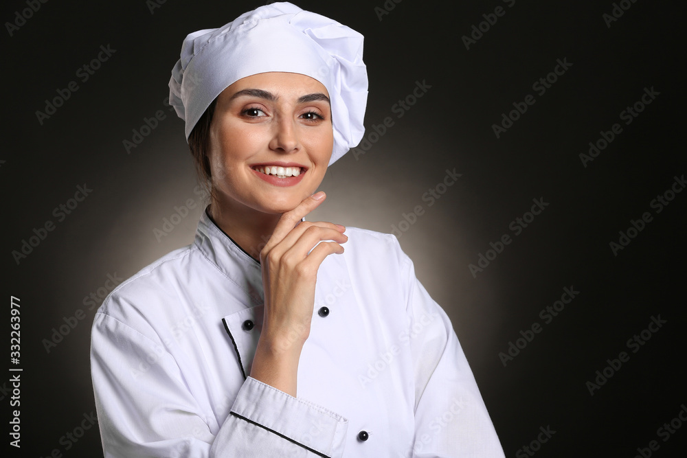 Portrait of female chef on dark background