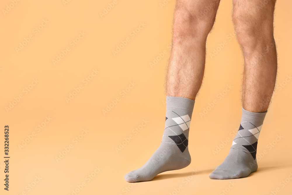 Male legs in socks on color background