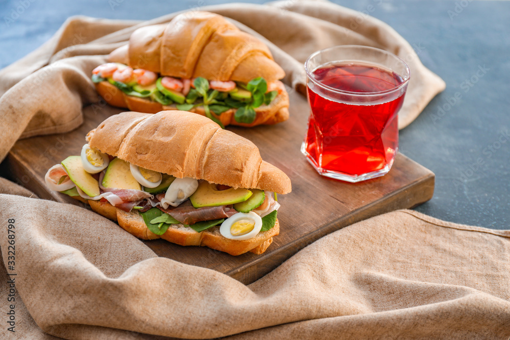 Tasty croissant sandwiches on table