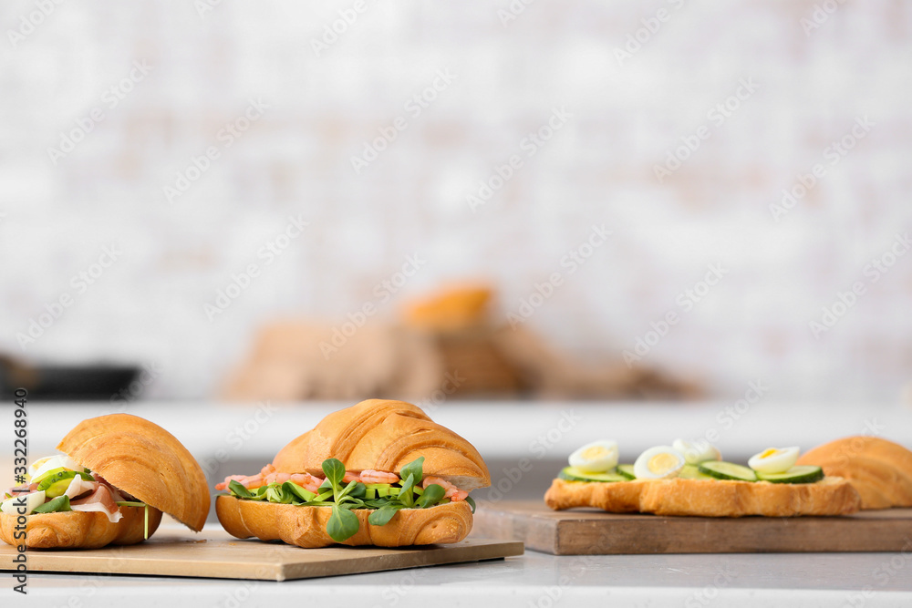 Tasty croissant sandwiches on table in kitchen