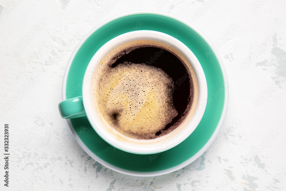 Cup of hot coffee on light background