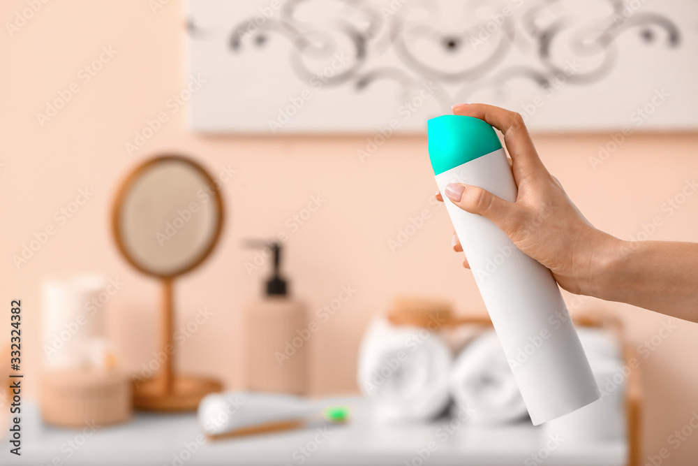 Woman spraying air freshener in room