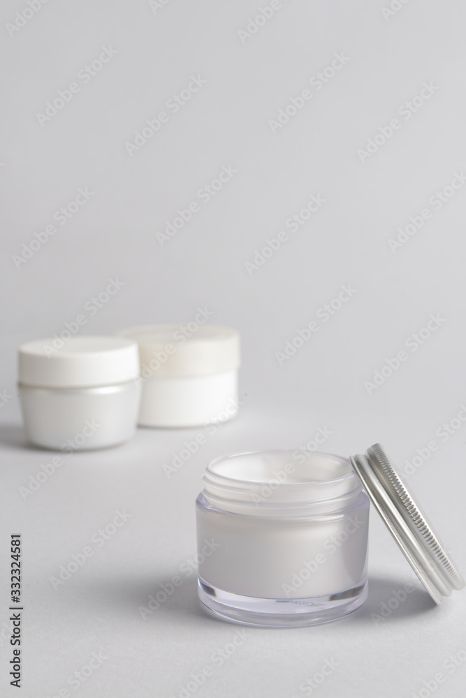 Jars of cream on light background