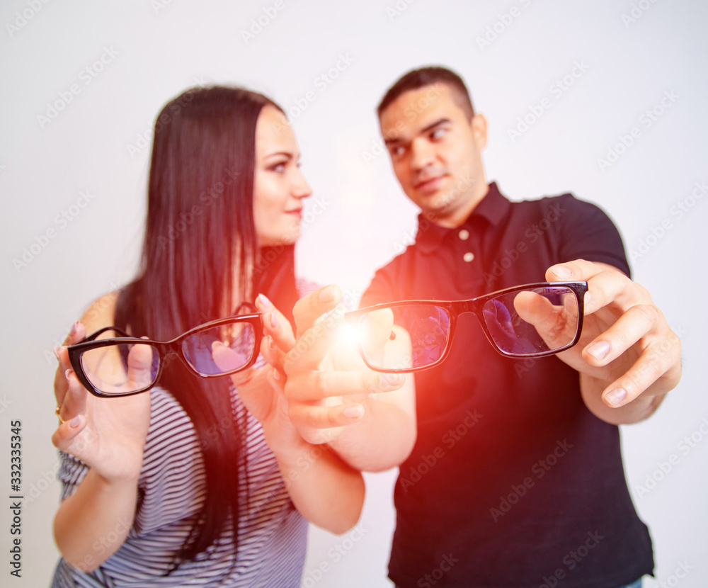 Lovely attractive couple sitting together and looking each other hold glasses in their hands. Young 