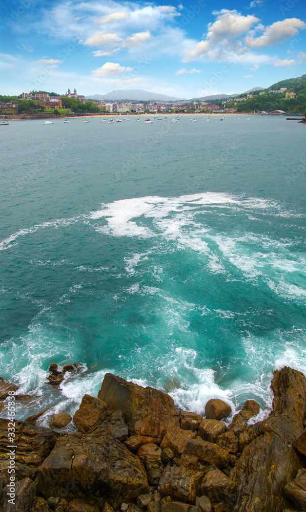 Ocean wave crashing on rock in the bay