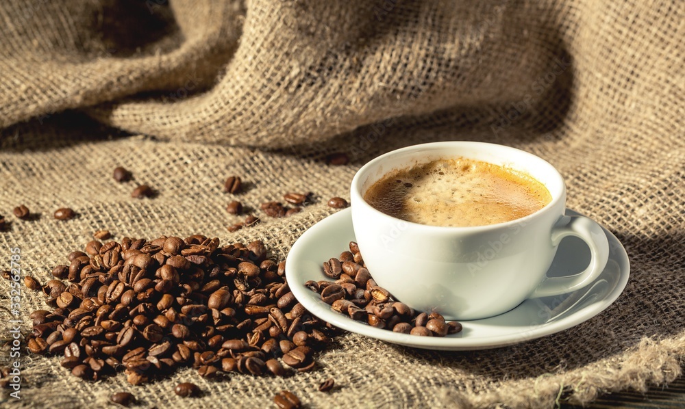 Aroma coffee beans and cup of coffee on the wooden table