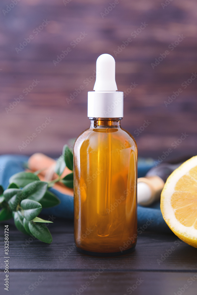 Bottle with essential oil on wooden background