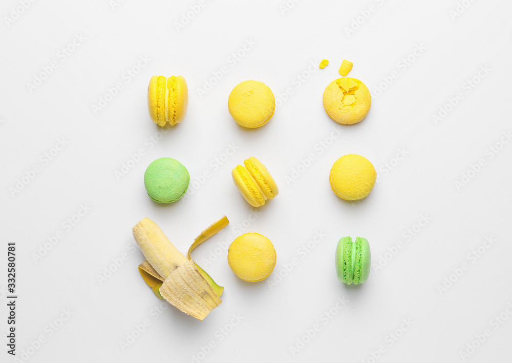 Tasty macarons with banana on white background