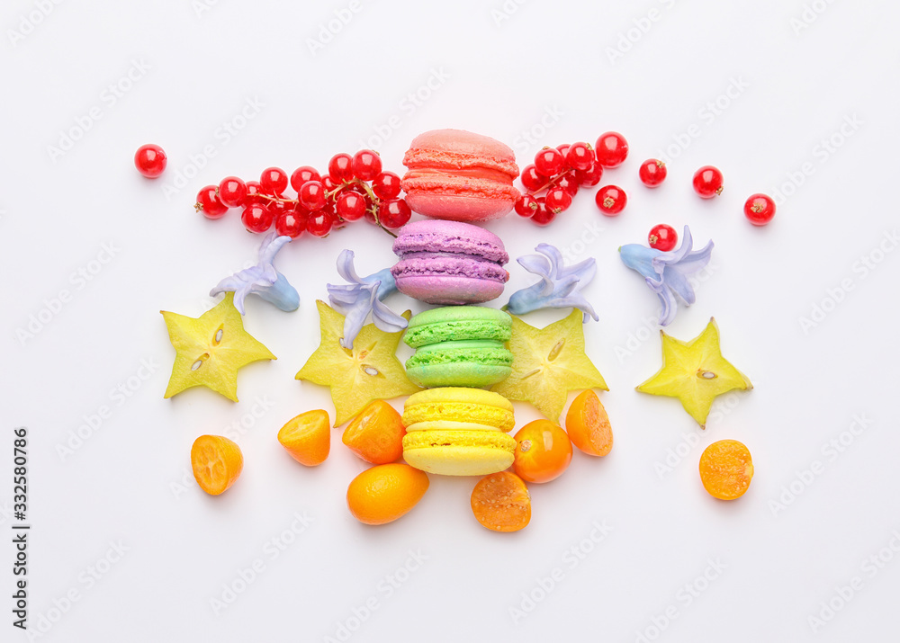 Tasty macarons with fruits on white background