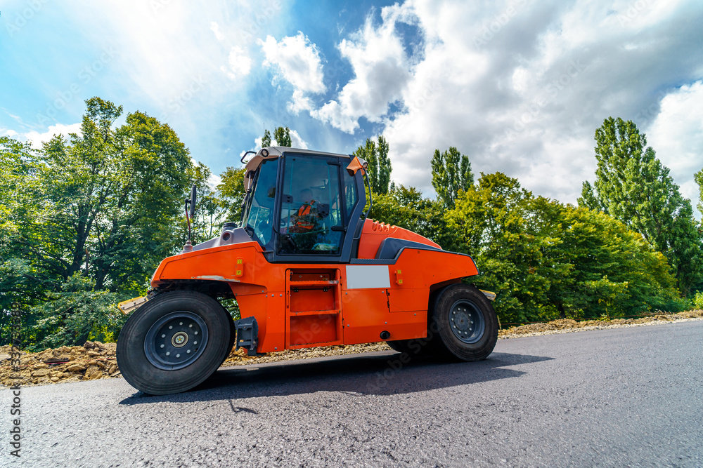 Road roller flattening new asphalt. Heavy Vibration roller at work paving asphalt, road repairing. S