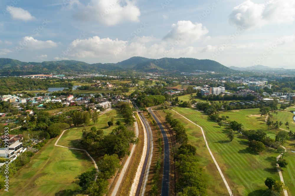 Asphalt road around the green golf field photo by Aerial view Drone shot.