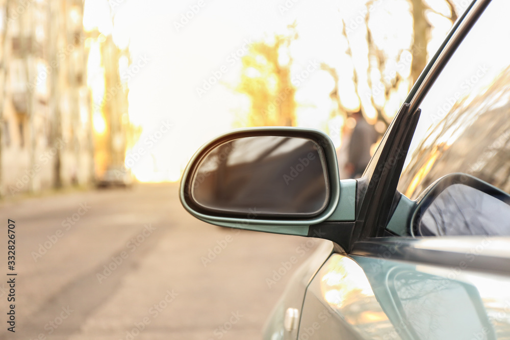 Side mirror of modern car on city street