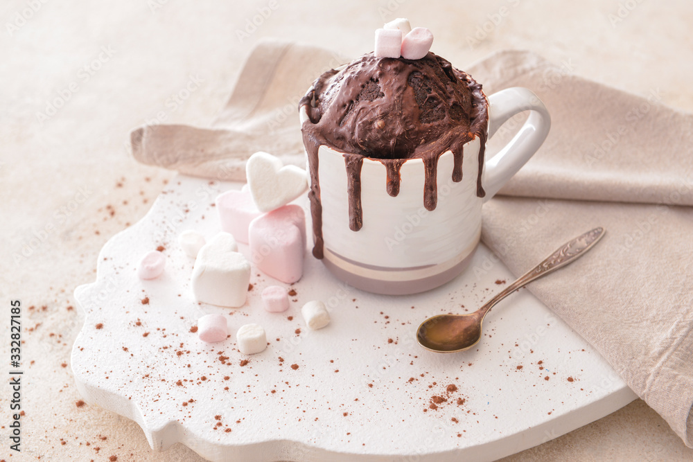 Chocolate mug cake with marshmallows on table