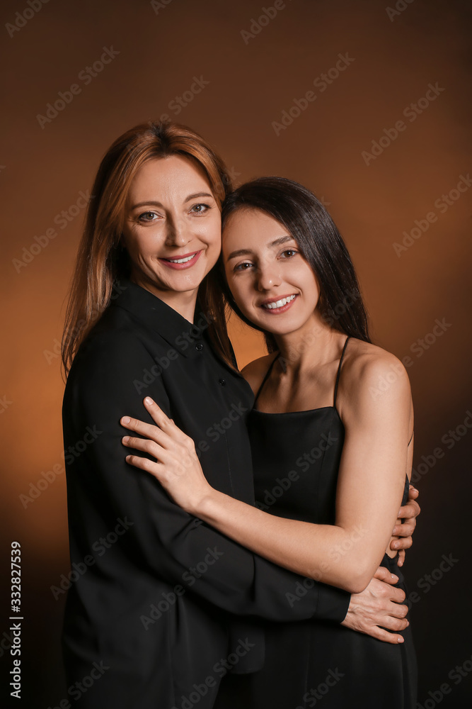 Portrait of young woman and mother on dark color background