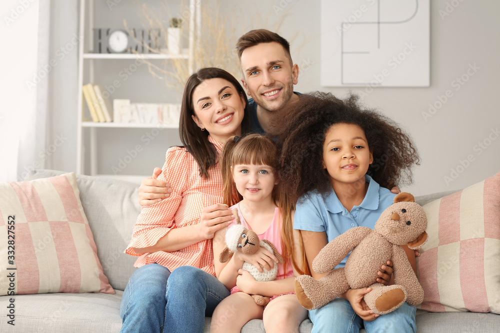 Happy couple with little adopted children at home