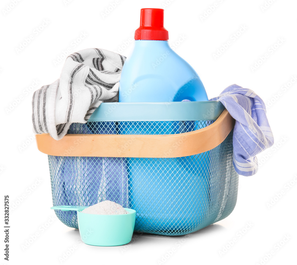 Basket with clothes and laundry detergents on white background