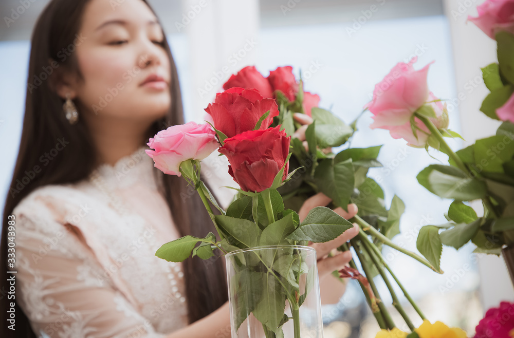 准备在家里修剪红色和粉色玫瑰以及美丽的插花的女人，花arr