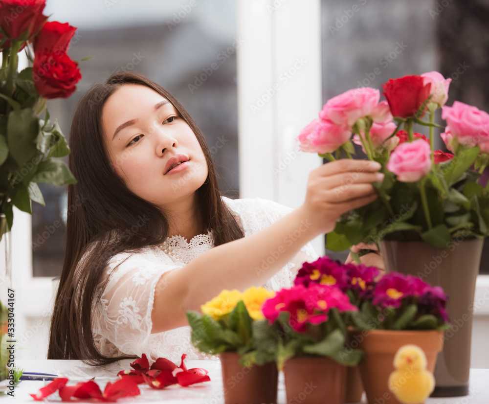 Woman Preparing to trim red and pink roses and beautiful flower arrangements in the home, flower arr