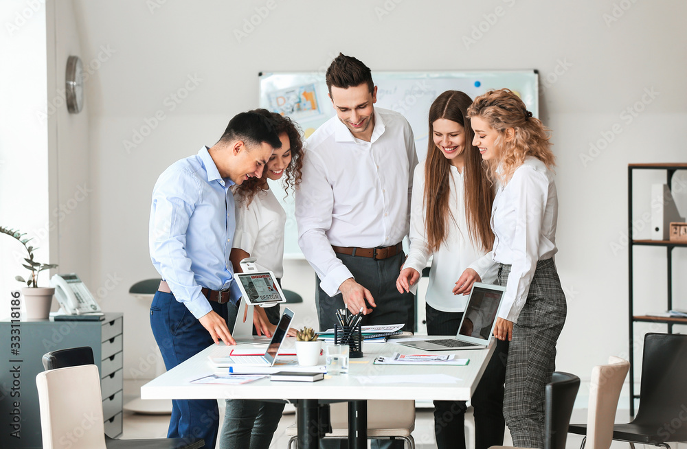 Male interior designer teaching young people in office