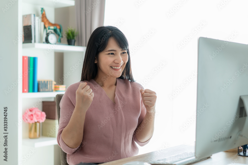 Beautiful Asian business woman work from home and celebrate with computer, success happy pose. E-com