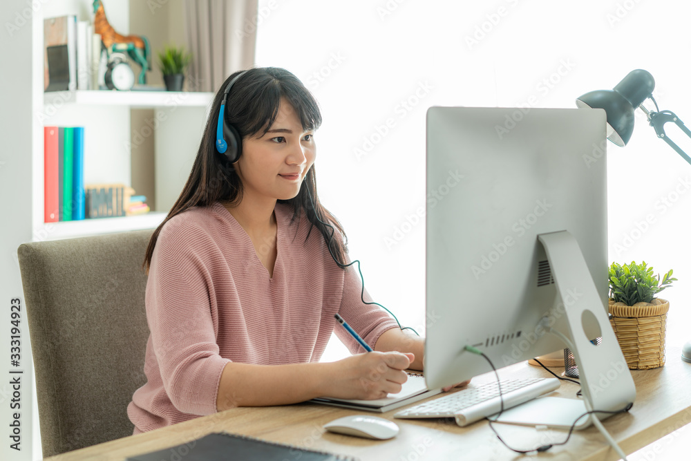 Asian woman student video conference e-learning with teacher on computer in living room at home. E-l