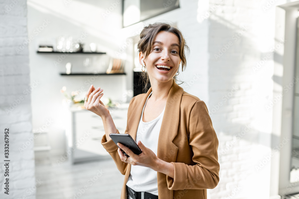 Portrait of a well-dressed woman having some business work on a smart phone while working from home