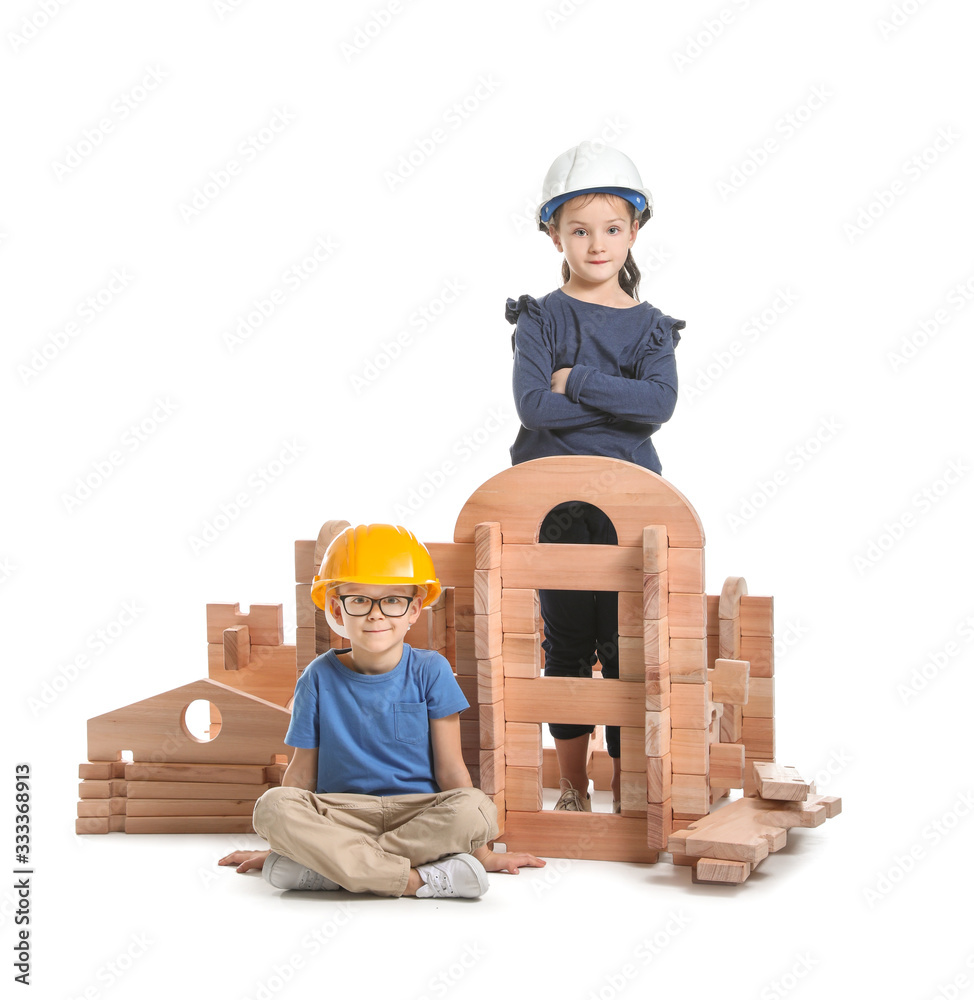 Little children dressed as builders playing with take-apart house on white background