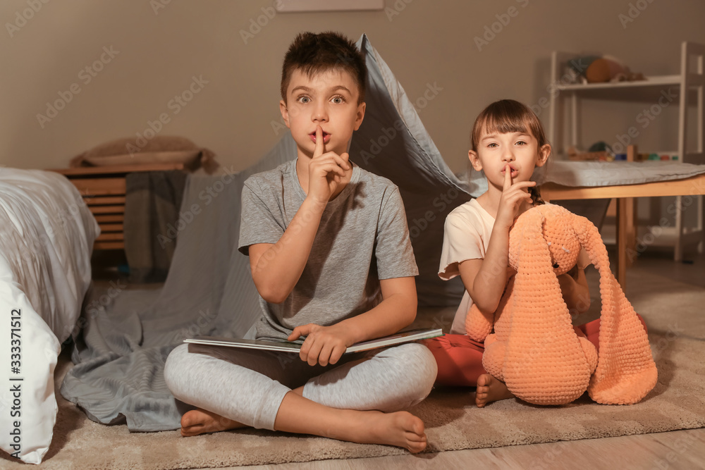 Little children reading bedtime story at home